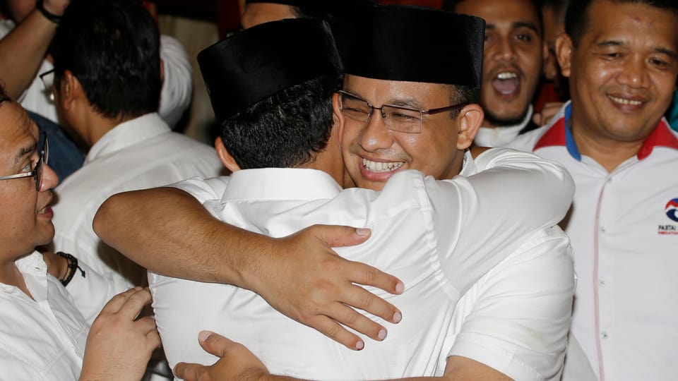 Anies Baswedan umarmt einen Kollegen.