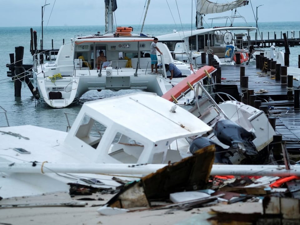 Zerstörte Boote an einem Hafensteg nach einem Sturm.