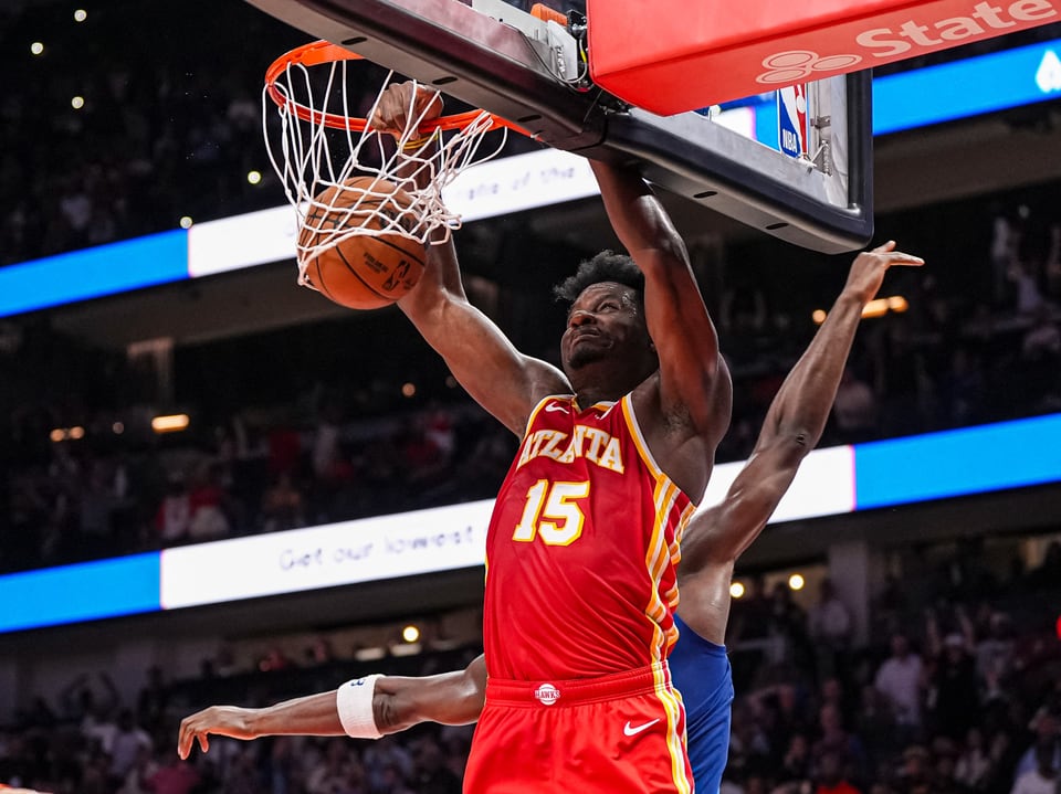 Basketballspieler dunkelt den Ball in einem Spiel.