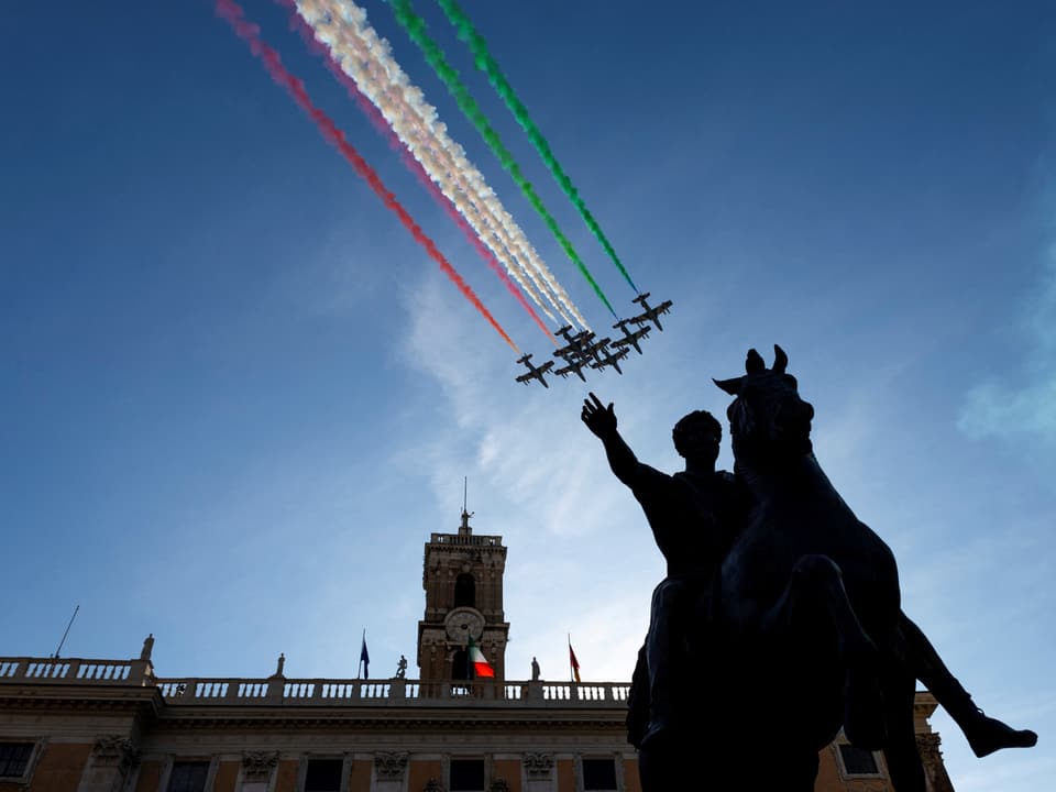 Flugzeuge bilden italienische Flagge über Reiterstatue.