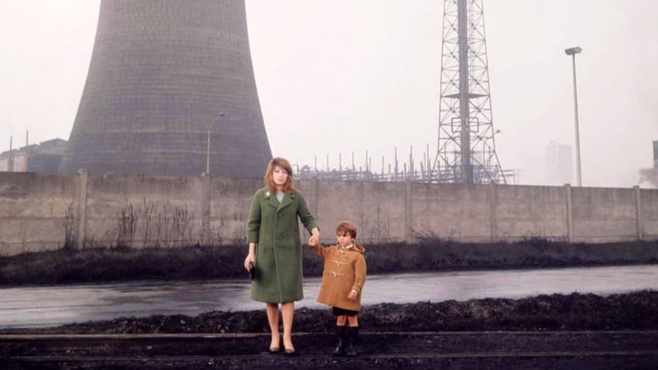 Eine Frau und ein Kind stehen vor einem Atomkraftwerk