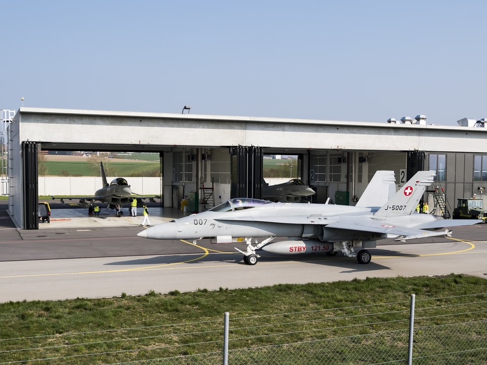 Schweizer Kampfflugzeuge vor einem Hangar.