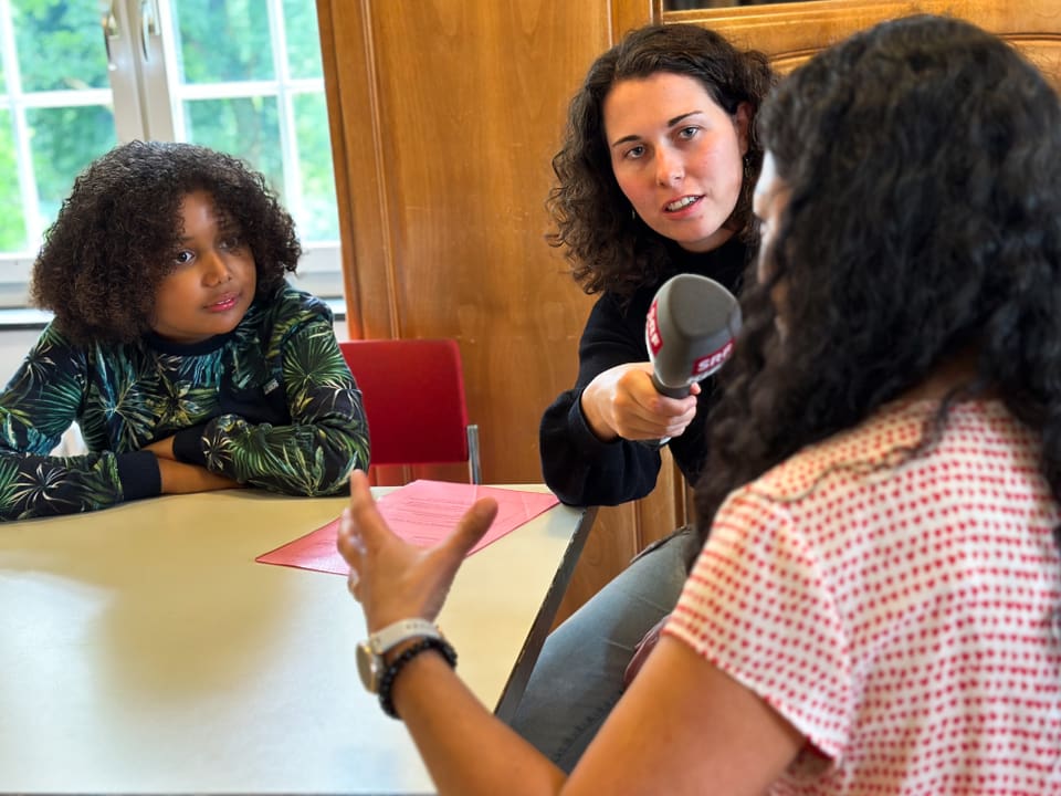 Ein Junge und eine Reporterin interviewen eine Frau