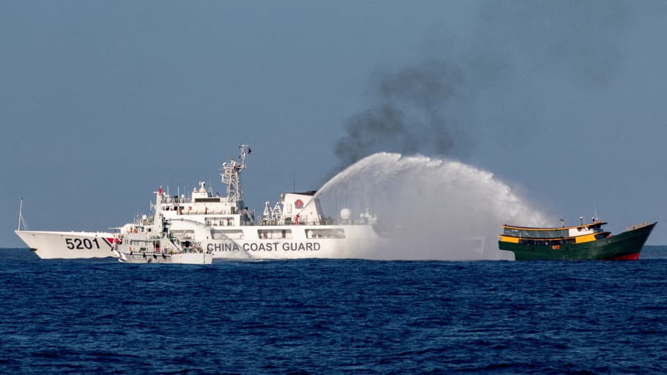 Chinesisches Küstenschutzschiff spritzt Wasser auf ein anderes Schiff.