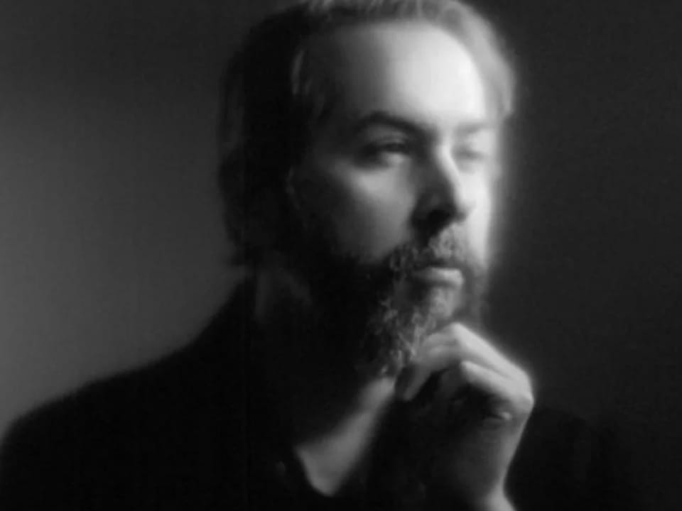 Porträt eines nachdenklichen Mannes mit Bart, schwarz-weiss.