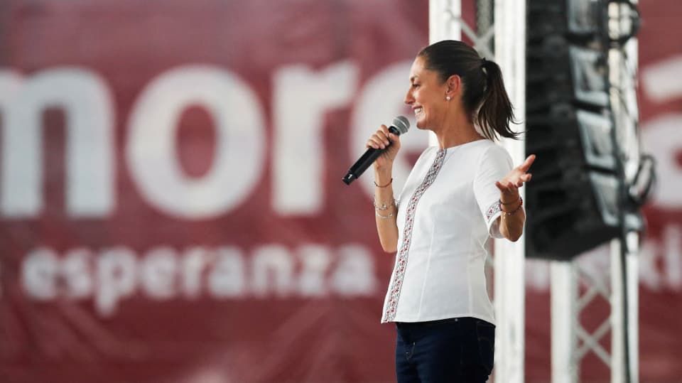 Die ehemalige Stadtpräsidentin von Mexiko-Stadt, Claudia Sheinbaum, steht mit einem Mikrofon auf einer Bühne.
