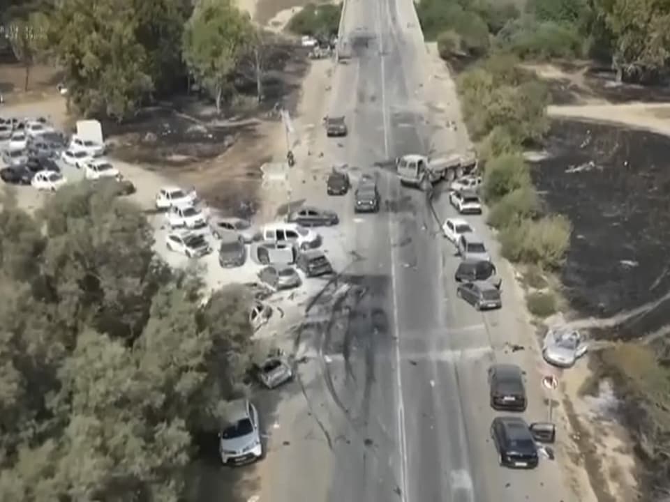verkohlte und beschädigte Autos entlang einer Wüstenstraße nach einem Angriff von militanten Hamas-Kämpfern  auf das musikfestival.