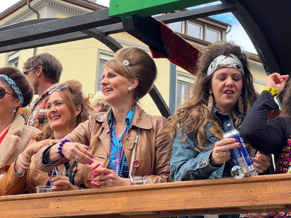 Vier Frauen in Retro-Outfits auf einer Parade.