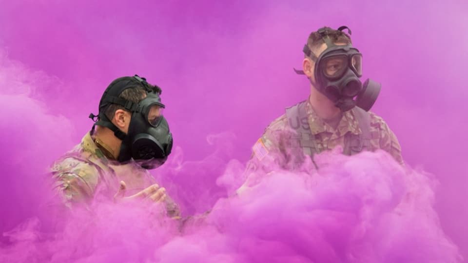 Two American soldiers test the effectiveness of their gas masks.