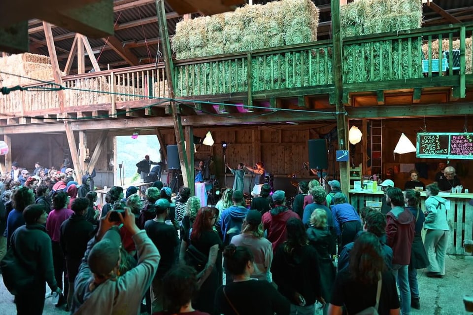 Menschenmenge beim Buatsch Festival in einer Scheune.