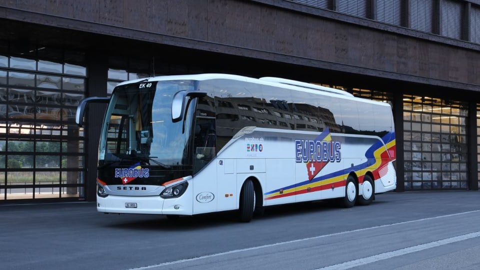 Ein Bus hält vor einem Gebäude an.