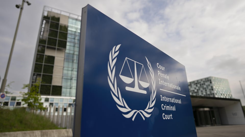 Blaues Schild des Internationalen Strafgerichtshofs vor dem Hauptgebäude.