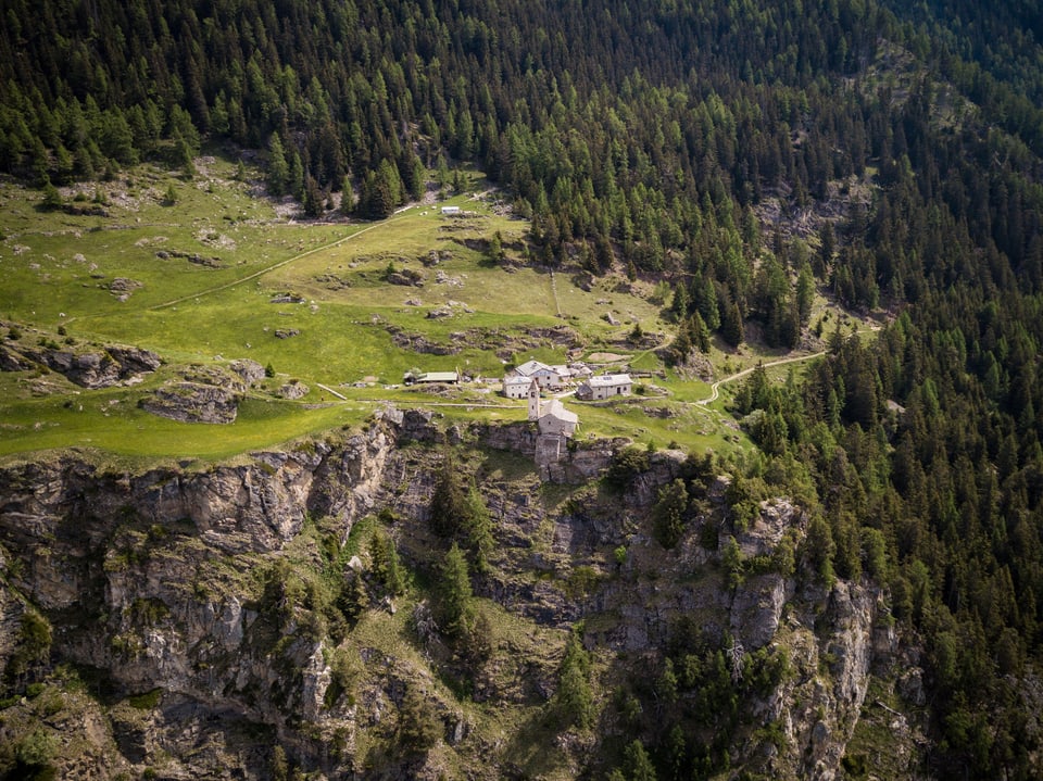 Spektakulärer Blick auf die Alp San Romerio, die oberhalb einer steilen Flanke liegt.