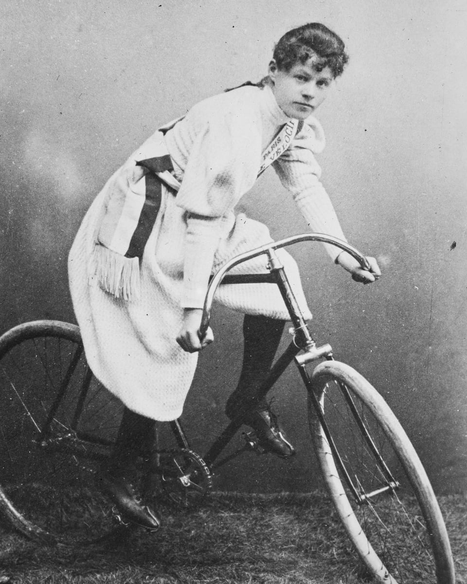 Frau auf historischem Fahrrad.