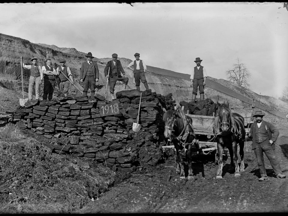 Historisches Bild mit Kohlearbeitern auf einem Kohlehaufen neben Pferdefuhrwerk.