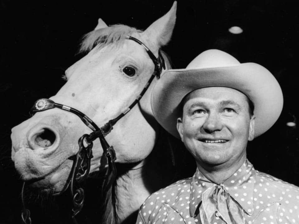 Tex Ritter mit Cowboy-Hut neben einem Pferd