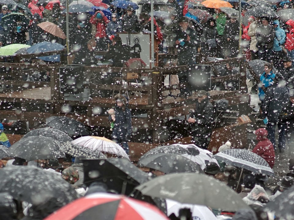 Schirme und Menschen im Schneeregen