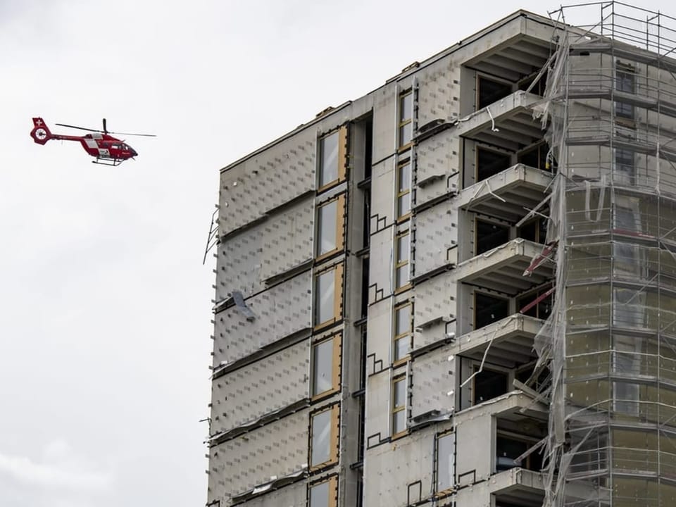 Roter Hubschrauber neben einem Hochhaus im Bau.