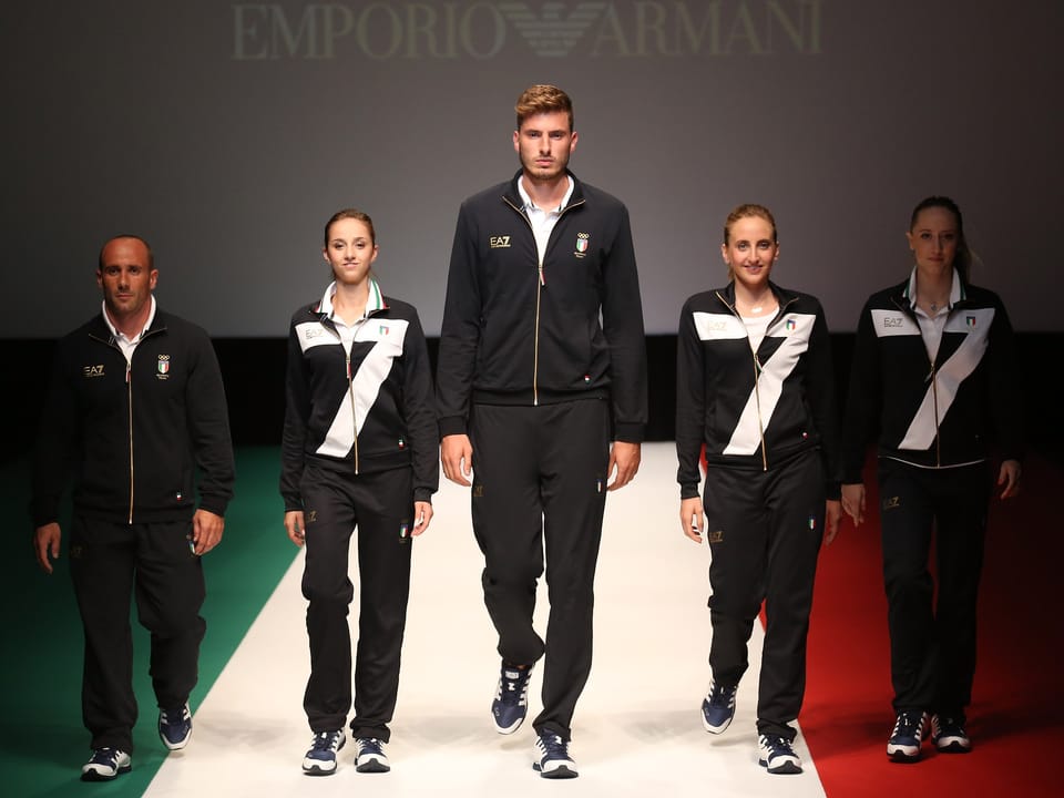 Mehrere Personen in Sportkleidung, die eine grosse 7 ziert, auf einem Laufsteg in Italiens Landesfarben.