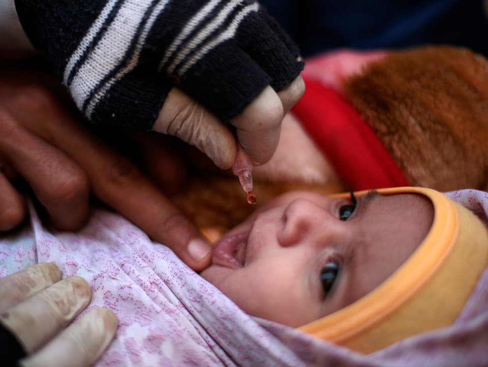 Einem Baby wird die orale Impfung verabreicht.