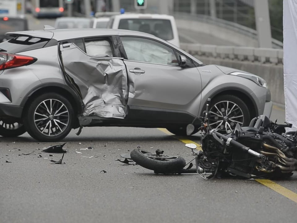 Auto und Motorrad nach Verkehrsunfall auf der Strasse.