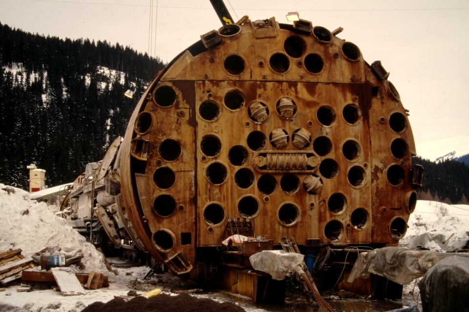 Tunnelbohrmaschine vor Wald und Schnee.