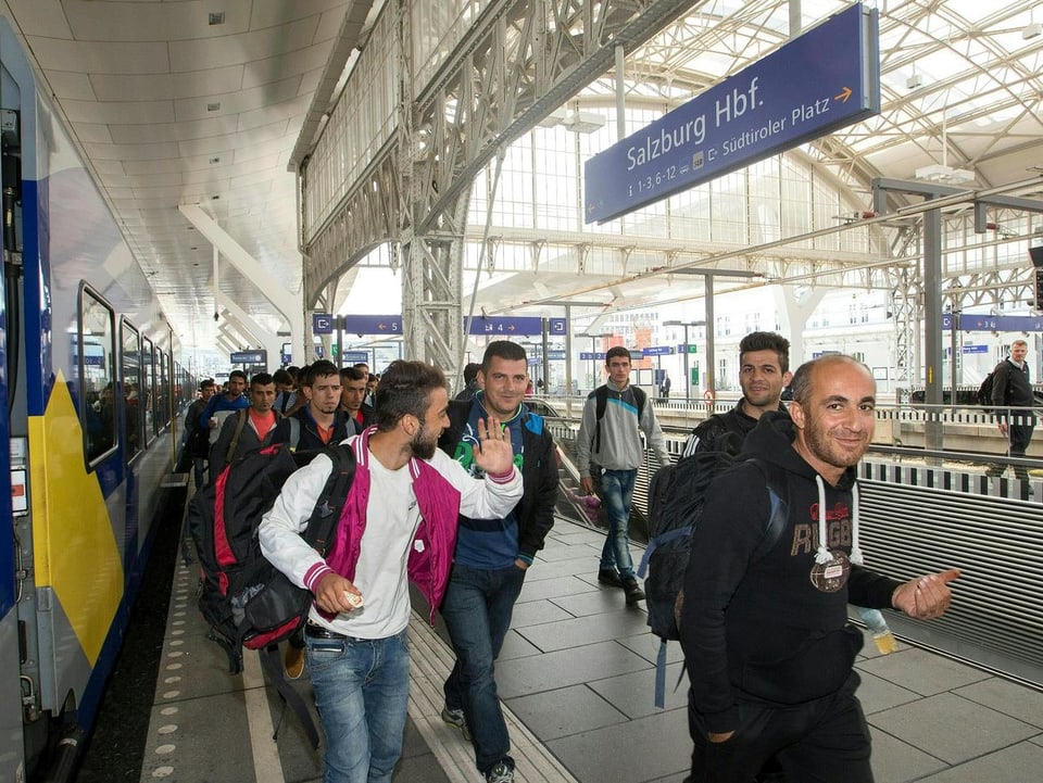 Lachende Migranten bei Ihrer Ankunft am Bahnhof Salzburg. 