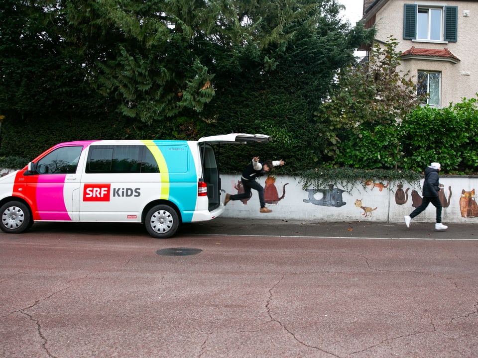 Zwei Kinder springen aus dem Kofferraum des SRF Kids Bus.