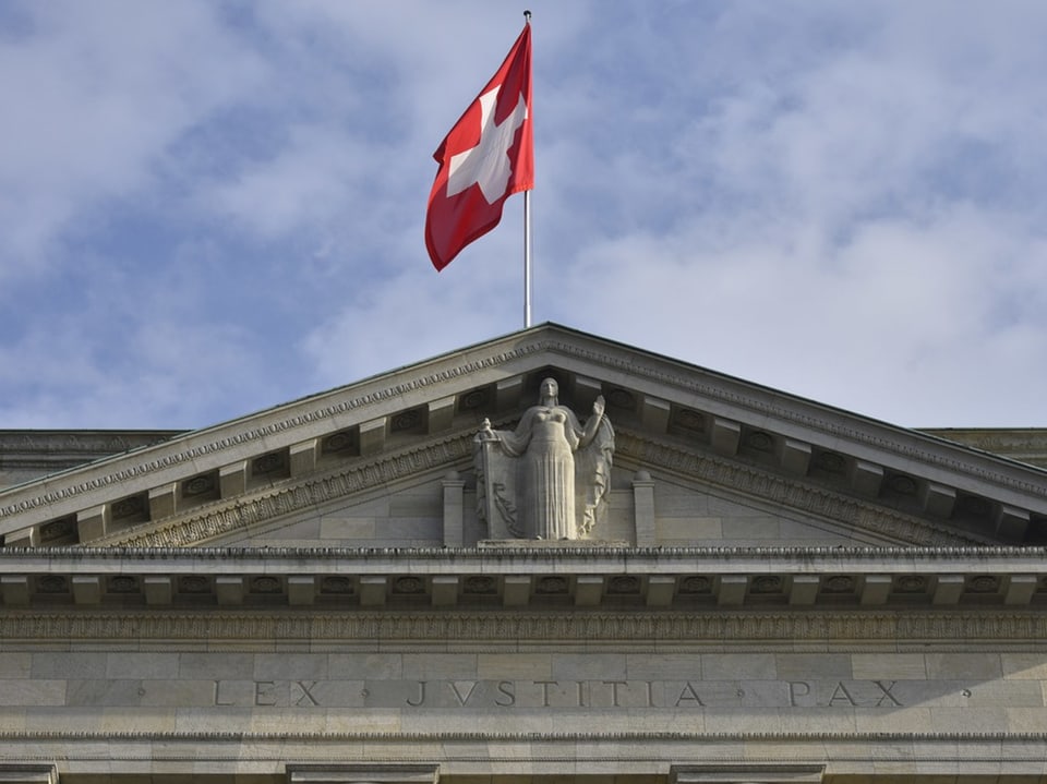 Schweizer Flagge auf Gebäude mit Inschrift LEX JVSTITIA PAX.