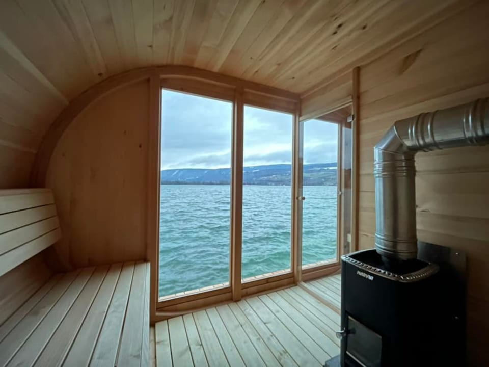 Blick von einer schwimmenden Sauna auf den See. 