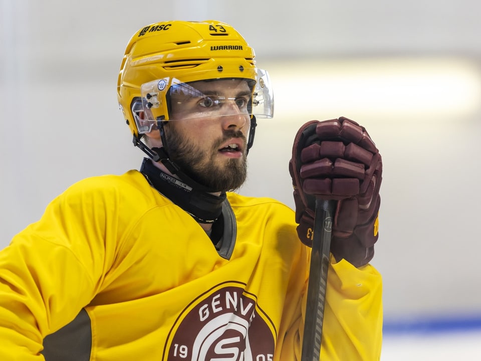 Eishockeyspieler im Geneva-Servette-Trikot und gelbem Helm.