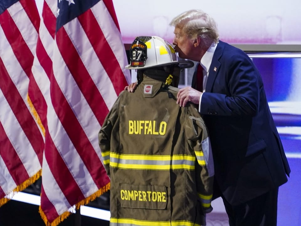 Trump küsst die Uniform des getöteten Feuerwehrmanns.
